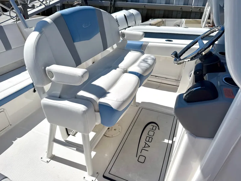 Slide: The Image of The image shows the cockpit of a 2025 Robalo R232 Explorer with a cushioned double seat and helm. - 8