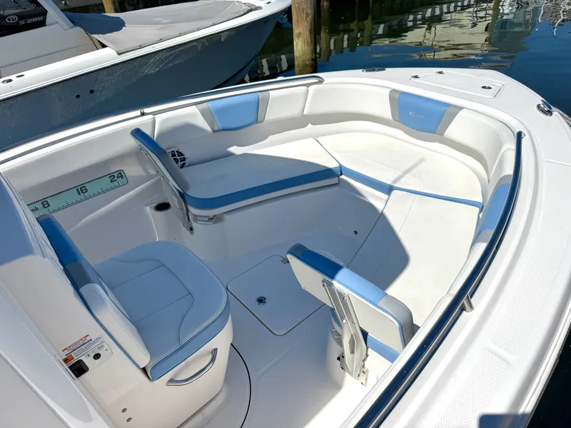Slide: The Image of The image shows the cockpit of a 2025 Robalo R232 Explorer with blue and white seating. - 10