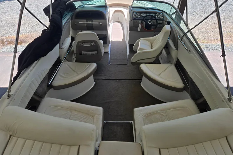 Slide: The Image of Interior of a 2005 Cobalt 250 boat with white leather seating and steering console. - 11