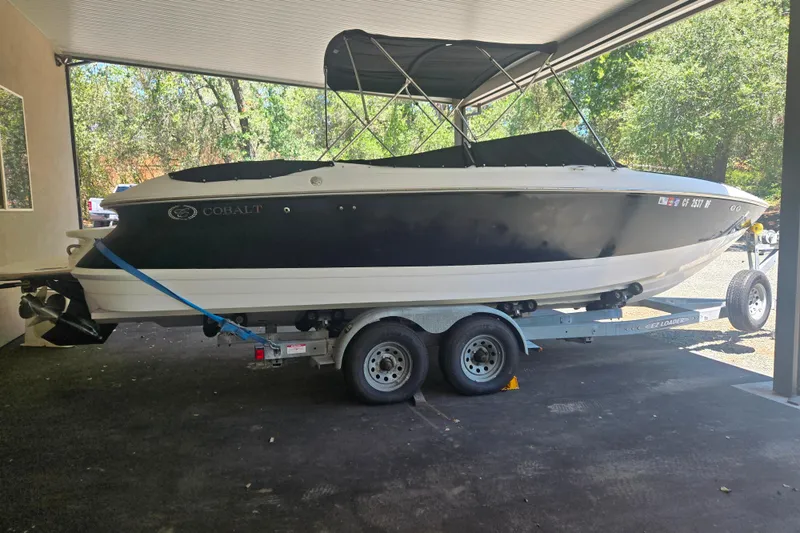 Slide: The Image of 2005 Cobalt 250 boat on trailer under a canopy, side view. - 2