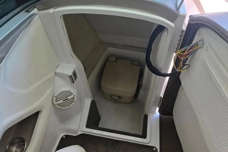 Slide: The Image of Interior of a 2005 Cobalt 250 boat showing a compact toilet and wiring. - 12