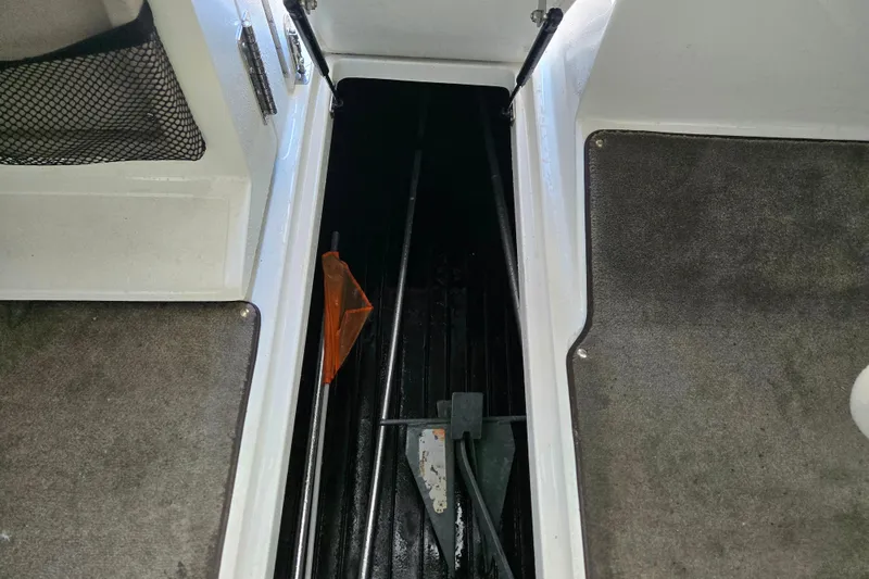 Slide: The Image of Interior view of a 2005 Cobalt 250 boat storage compartment with carpeted flooring. - 13