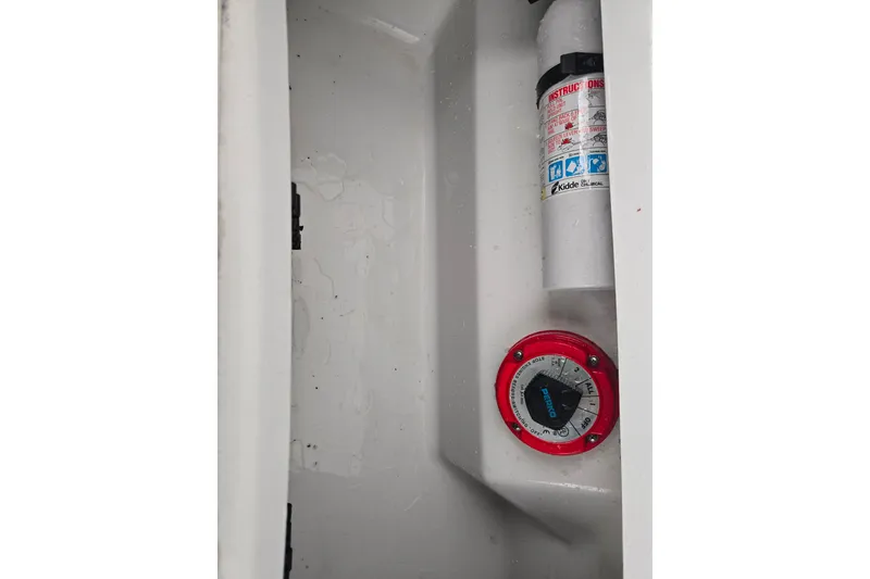 Slide: The Image of Fire extinguisher and battery switch in 2005 Cobalt 250 boat compartment. - 16