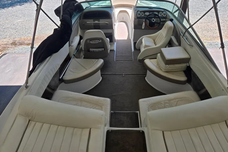 Slide: The Image of Interior of a 2005 Cobalt 250 boat with white leather seating and steering console. - 7