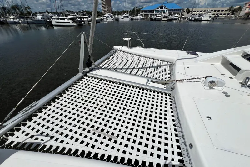 Slide: The Image of 2008 Admiral 40 Cruiser catamaran with netting, docked at a marina under a cloudy sky. - 20