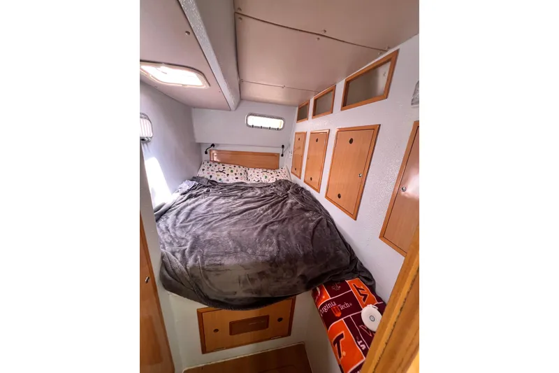 Slide: The Image of Cozy cabin bedroom in a 2008 Admiral 40 cruiser with wooden storage cabinets. - 56