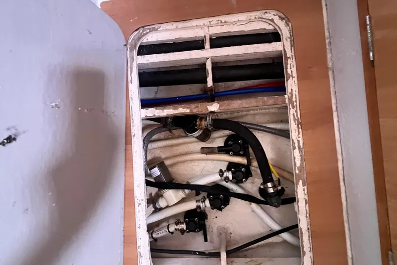Slide: The Image of Boat plumbing system inside 2008 Admiral 40 Cruiser, featuring various hoses and valves. - 76