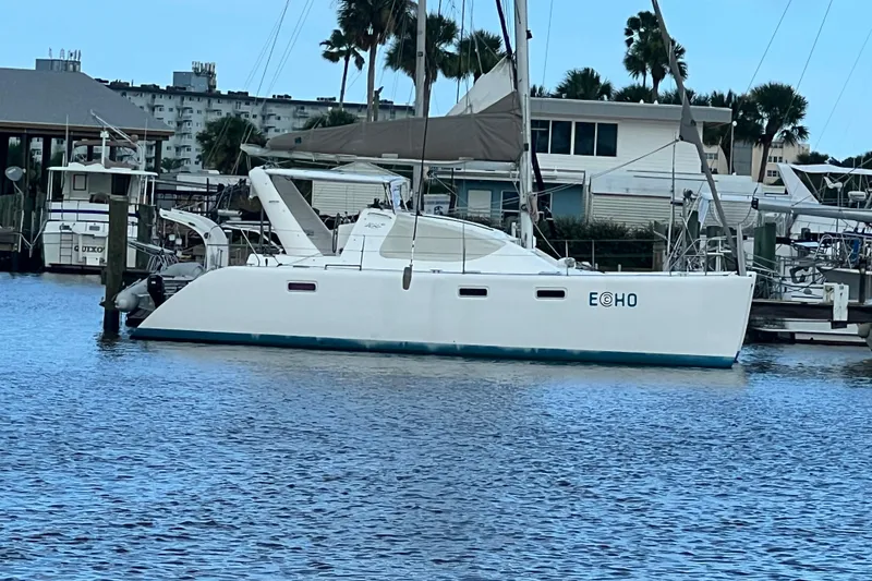 Slide: The Image of 2008 Admiral 40 Cruiser sailboat docked in marina, surrounded by water and palm trees. - 1