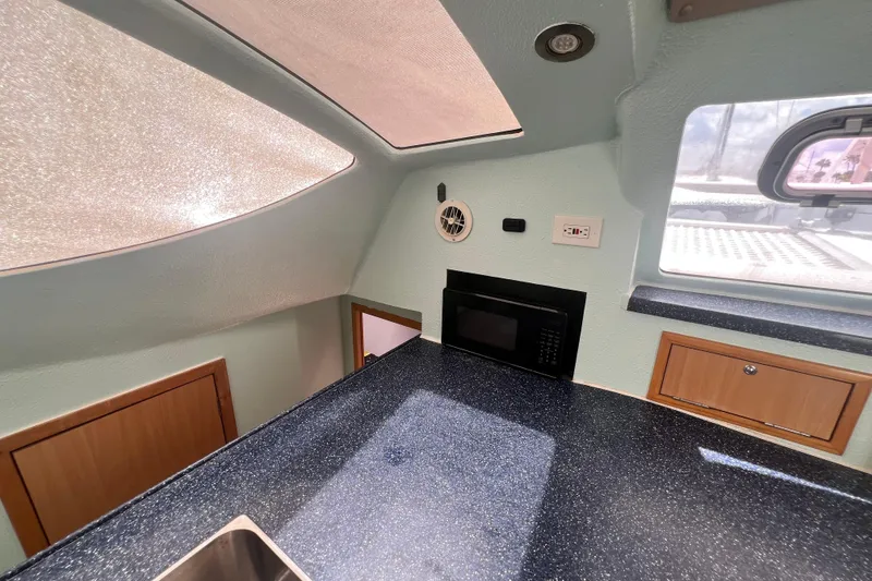 Slide: The Image of Interior of 2008 Admiral 40 Cruiser with modern kitchen, featuring microwave and sleek countertops. - 71