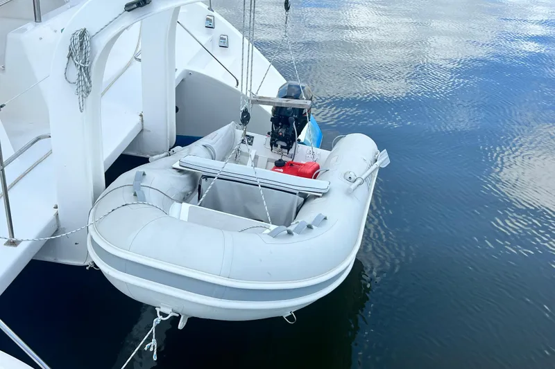 Slide: The Image of Inflatable dinghy suspended from Admiral 40 cruiser, 2008 model, over calm water. - 10