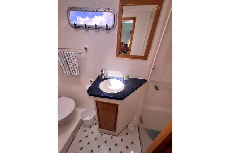 Slide: The Image of Bathroom interior of 2008 Admiral 40 Cruiser with sink, mirror, and porthole window. - 65