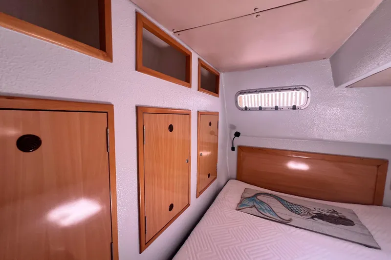 Slide: The Image of Cozy cabin interior of 2008 Admiral 40 Cruiser with wooden storage and porthole window. - 74