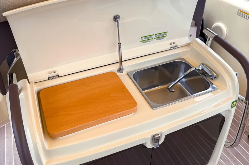 Slide: The Image of 2023 Invictus GT280S yacht kitchenette with sink and wooden cutting board. - 14