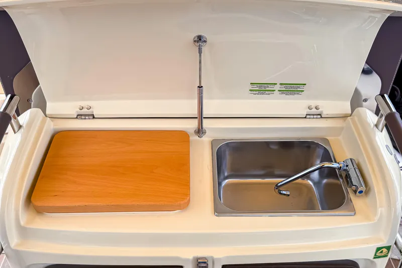Slide: The Image of 2023 Invictus GT280S boat kitchenette with sink and wooden cutting board. - 15