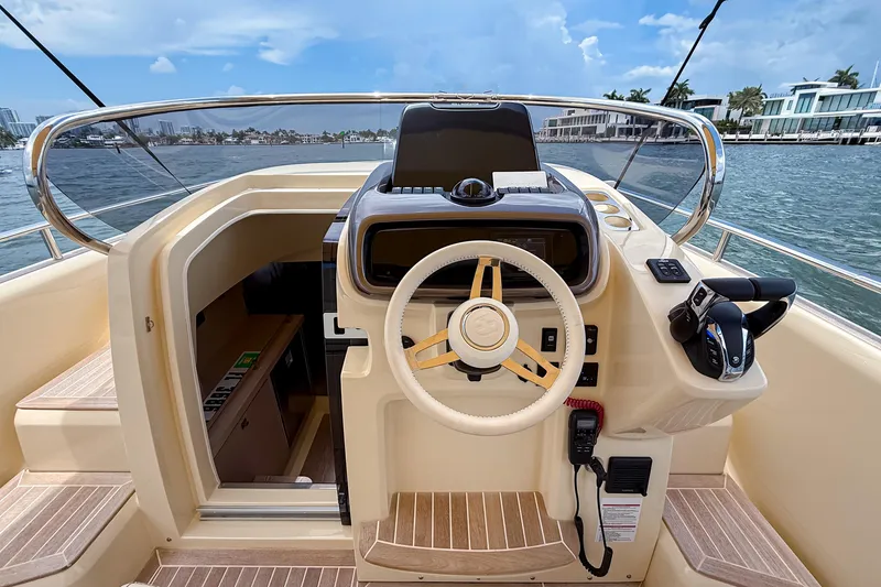 Slide: The Image of 2023 Invictus GT280S boat helm with modern controls and scenic waterfront view. - 19
