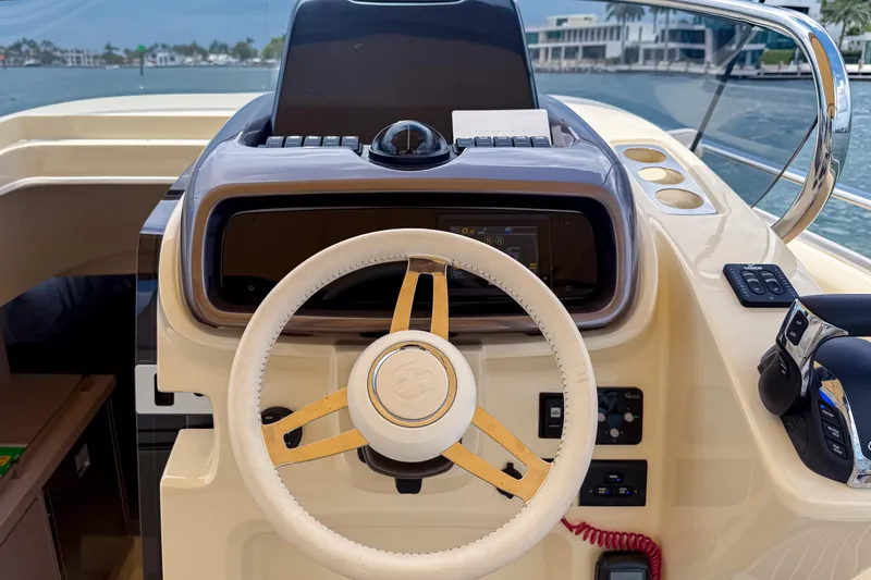 Slide: The Image of 2023 Invictus GT280S boat helm with steering wheel and control panel, dockside view. - 20