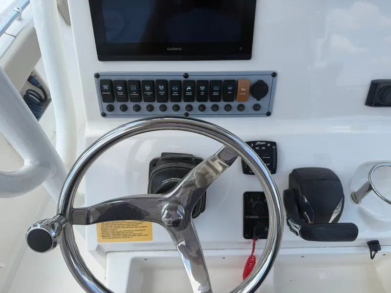 Slide: The Image of The image shows the helm of a Key West 239 FS boat with a modern steering wheel and electronic controls. - 13