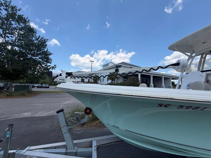 Slide: The Image of A 2023 Key West 239 FS boat on a trailer, parked in front of a building. - 18