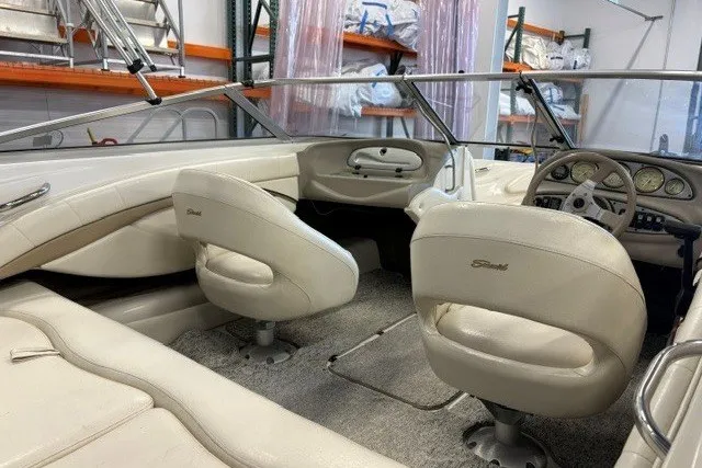 Slide: The Image of 2006 Seaswirl 190 Bowrider I/O interior with beige seating and dashboard in storage. - 6