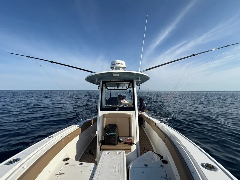 Slide: The Image of A 2021 Sea Hunt 265 Ultra on open water with fishing rods and a clear sky. - 7