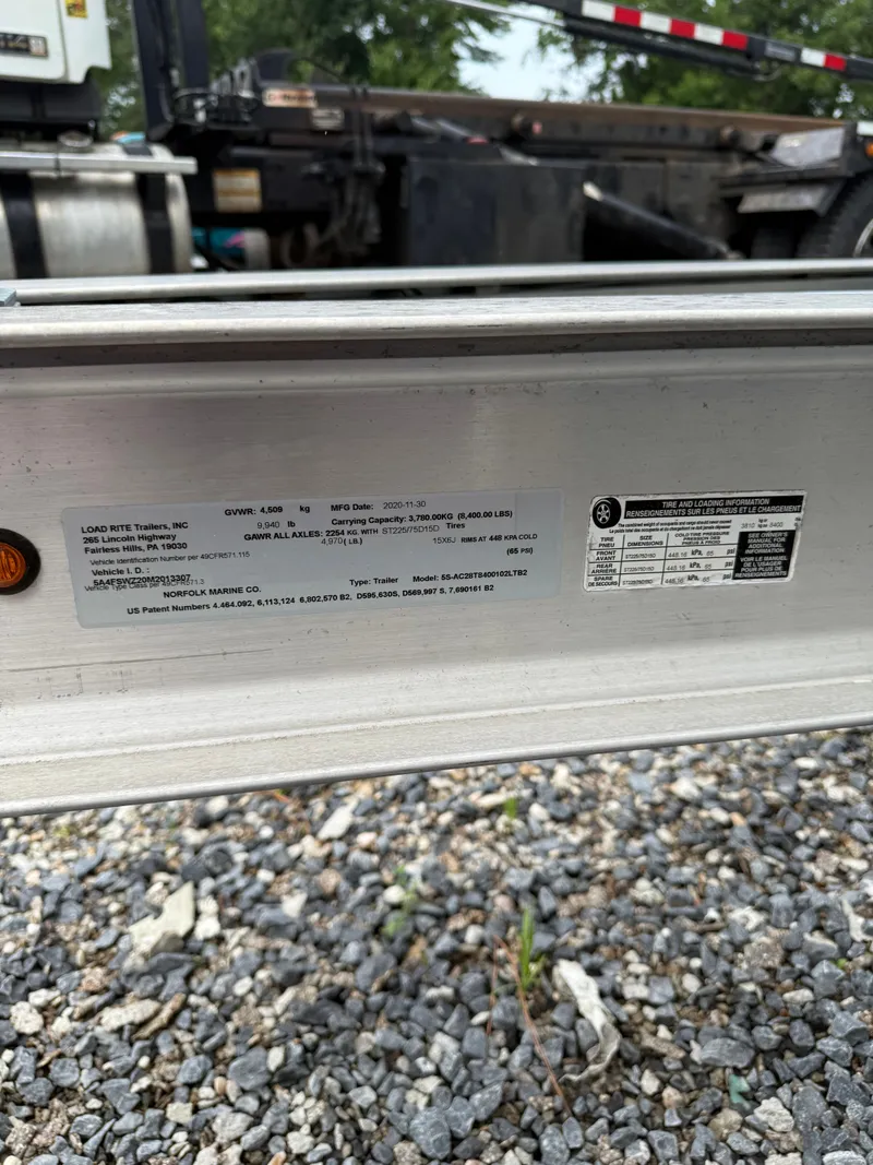 Slide: The Image of Close-up of a boat trailer with manufacturer label on a gravel surface. - 15
