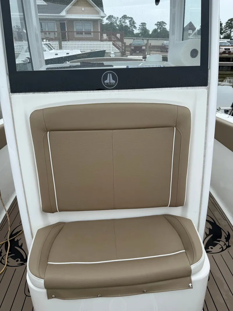 Slide: The Image of Brown cushioned seat on a boat with a white frame and clear view of the harbor. - 10