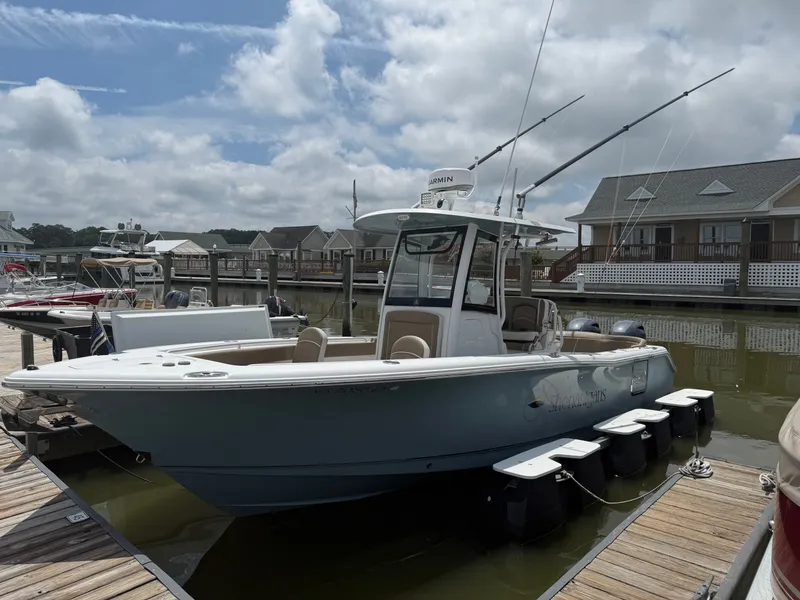 The Image of A 2021 Sea Hunt 265 Ultra docked. It features a blue hull and fishing rods. - 0