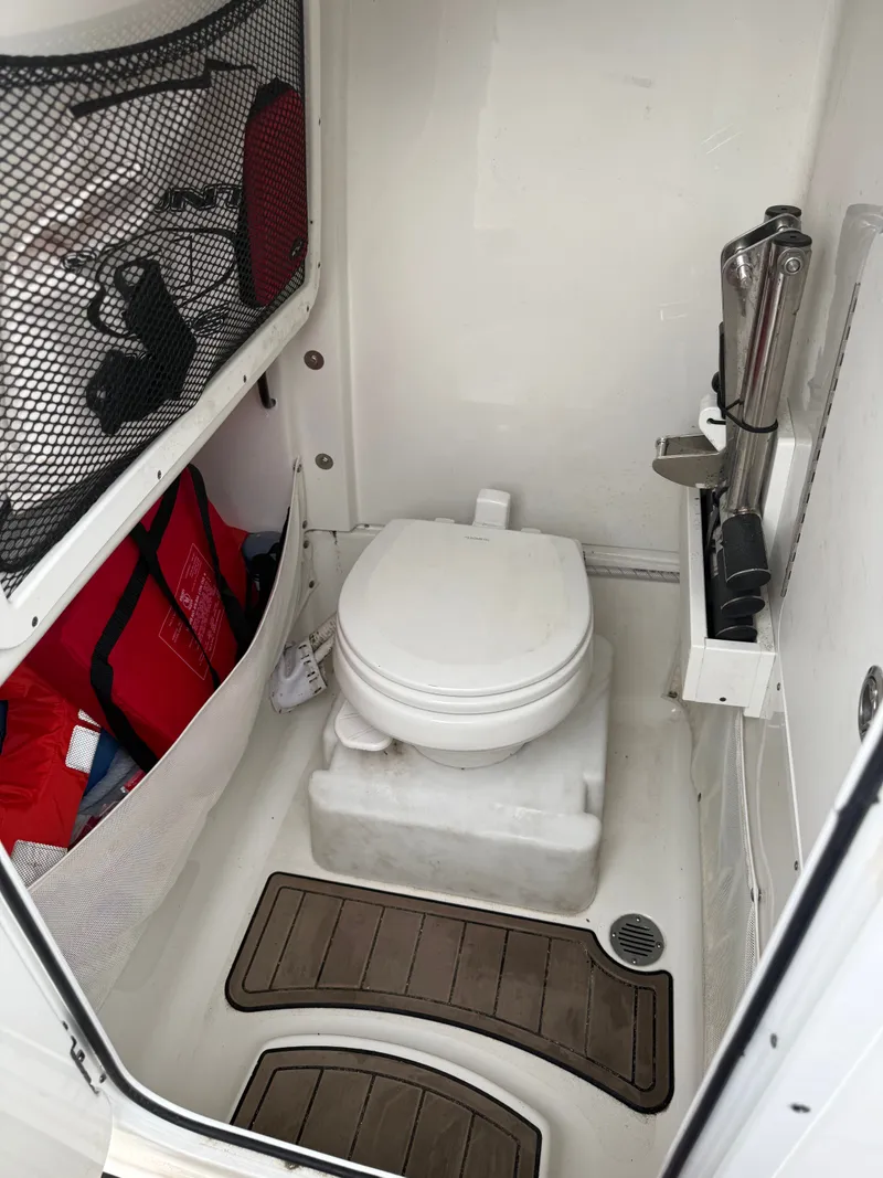 Slide: The Image of 2021 Sea Hunt 265 Ultra featuring a compact toilet and storage area. - 8