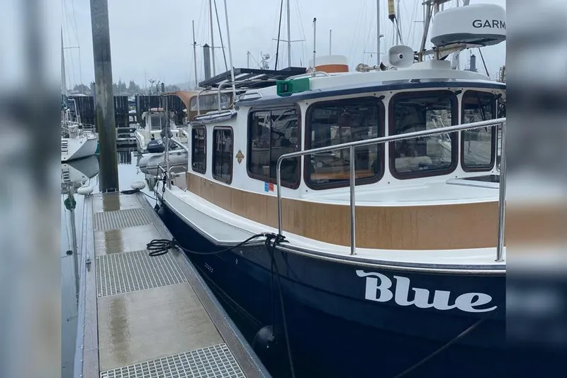 Slide: The Image of 2016 Ranger Tugs R-27 boat named "Blue" docked at a marina. - 14