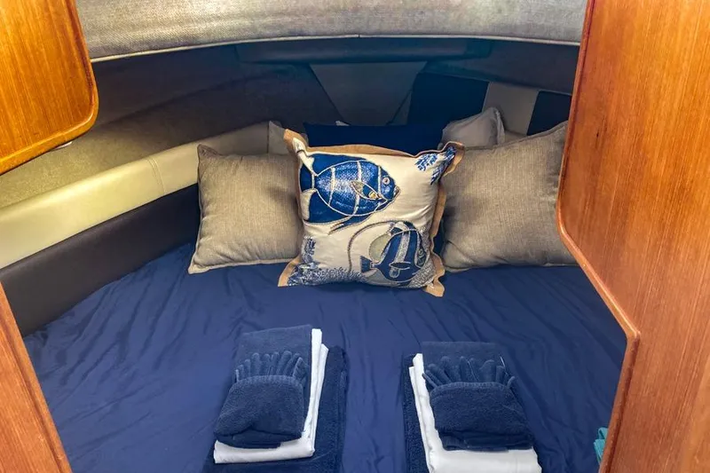 Slide: The Image of Cozy cabin interior of 2016 Ranger Tugs R-27 with nautical-themed pillows and neatly folded towels. - 4