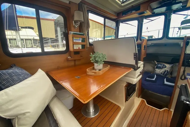 Slide: The Image of Interior of 2016 Ranger Tugs R-27 boat with cozy seating and wooden table. - 8