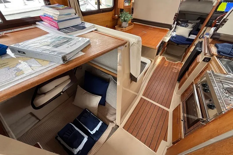 Slide: The Image of Interior of a 2016 Ranger Tugs R-27 boat, featuring cozy cabin and kitchen area. - 3