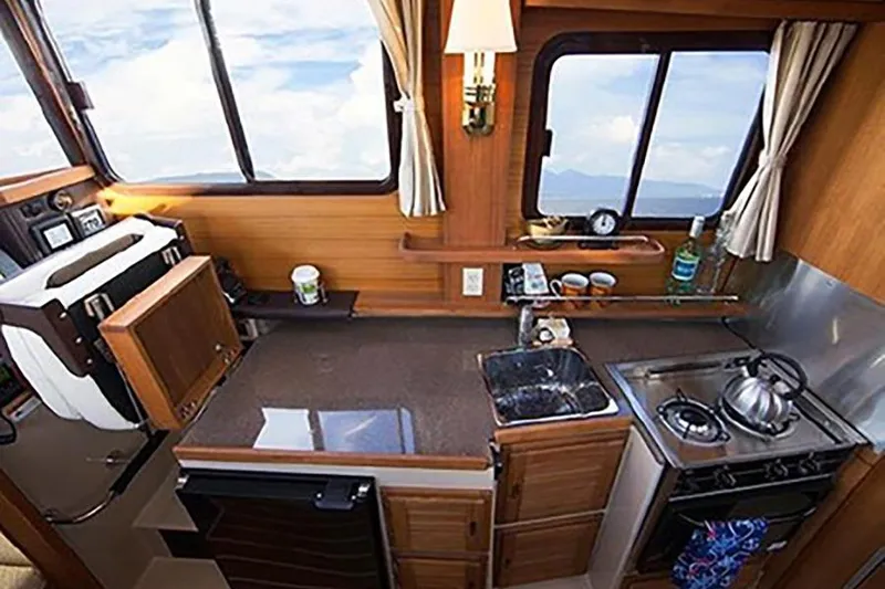 Slide: The Image of Compact kitchen interior of 2016 Ranger Tugs R-27 boat with stove and sink. - 13