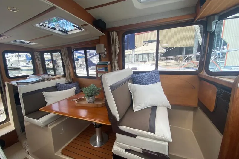 Slide: The Image of Interior of 2016 Ranger Tugs R-27 boat with cozy seating and dining area. - 9
