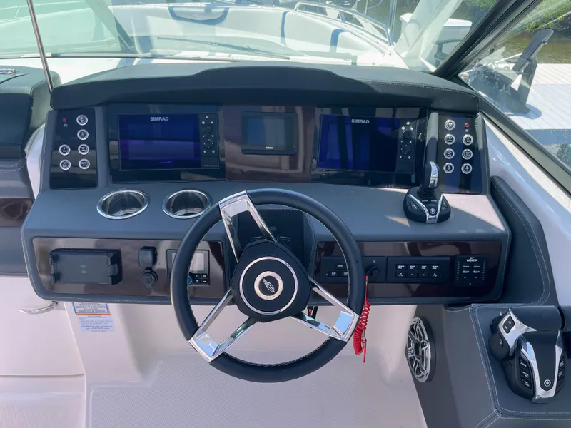 Slide: The Image of The image shows the helm of a 2023 Chaparral 280OSX with modern instruments and a sleek steering wheel. - 39