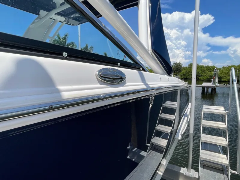 Slide: The Image of The 2023 Chaparral 280OSX is docked. It features a sleek design with blue paneling. - 23