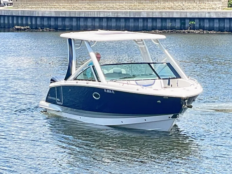 Slide: The Image of A 2023 Chaparral 280OSX glides on calm water. It features a sleek design and open cockpit. - 5