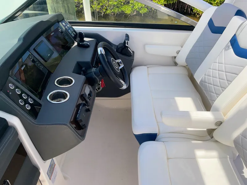 Slide: The Image of The image shows the cockpit of a 2023 Chaparral 280OSX with modern instruments and white seating. - 41
