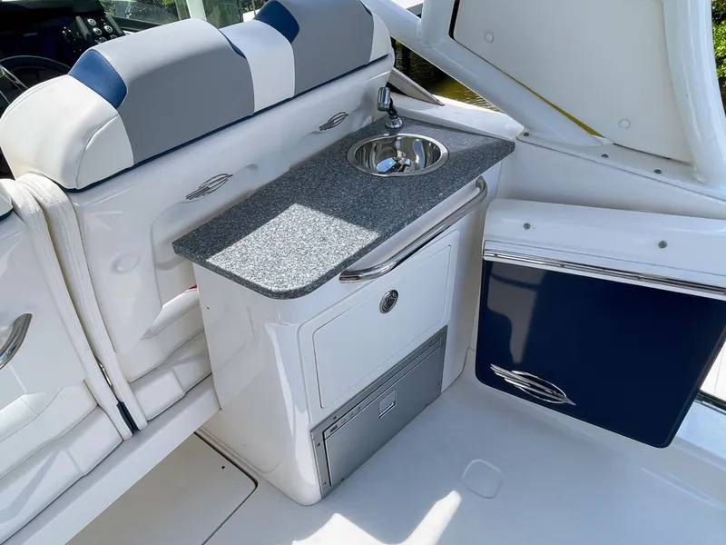 Slide: The Image of The 2023 Chaparral 280OSX features a sleek onboard kitchenette with a sink and storage. - 31