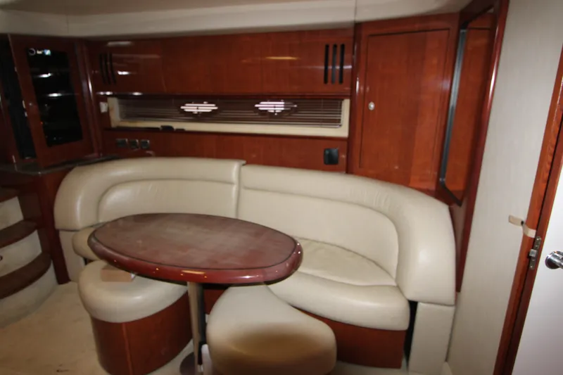 Slide: The Image of Interior of 2005 Sea Ray 420 Sundancer yacht with leather seating and wooden table. - 16