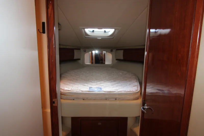 Slide: The Image of Cozy cabin interior of 2005 Sea Ray 420 Sundancer yacht with bed and wooden accents. - 18