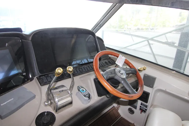 Slide: The Image of Helm of 2005 Sea Ray 420 Sundancer with wooden steering wheel and control panels. - 7