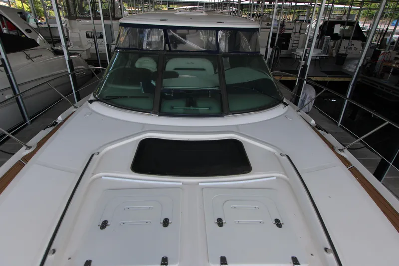 Slide: The Image of 2005 Sea Ray 420 Sundancer yacht docked in a marina, showcasing sleek design and spacious deck. - 12