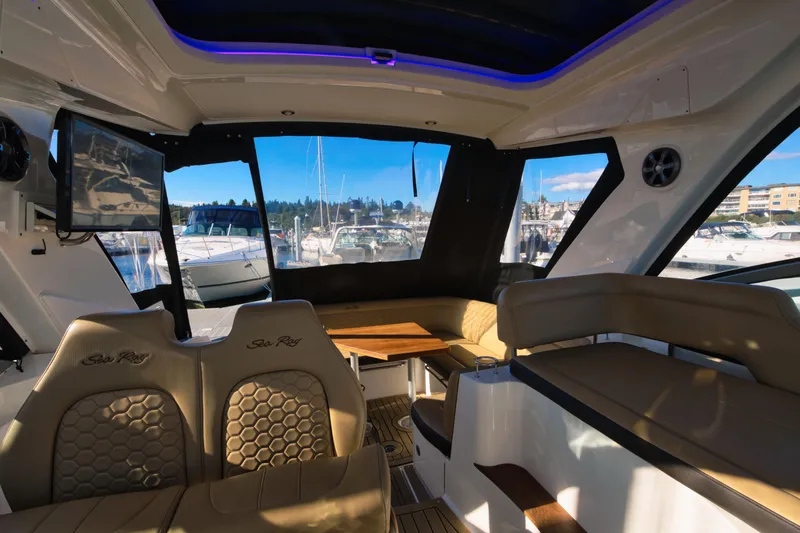 Slide: The Image of Interior of a Sea Ray Sundancer 350 with beige seating and a wooden table, surrounded by windows. - 4