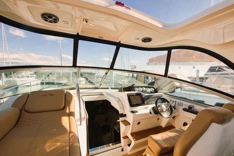 Slide: The Image of The cockpit of a 2021 Sea Ray Sundancer 350 with comfortable seating and modern electronics. - 10