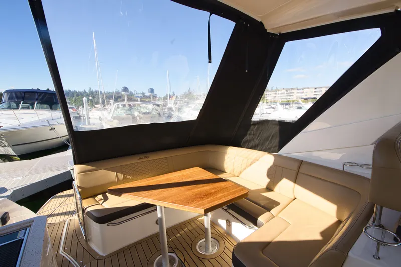 Slide: The Image of The 2021 Sea Ray Sundancer 350 features a cozy outdoor seating area with a wooden table. - 6