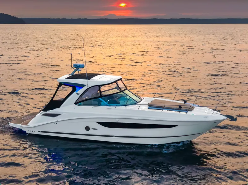The Image of The 2021 Sea Ray Sundancer 350 cruising on calm waters at sunset. - 0