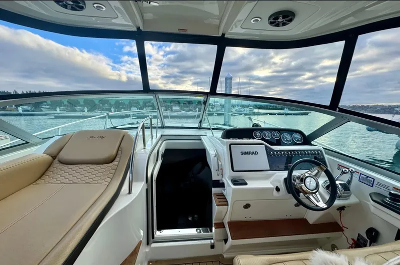 Slide: The Image of The cockpit of a 2021 Sea Ray Sundancer 350 with a modern helm and panoramic view. - 19