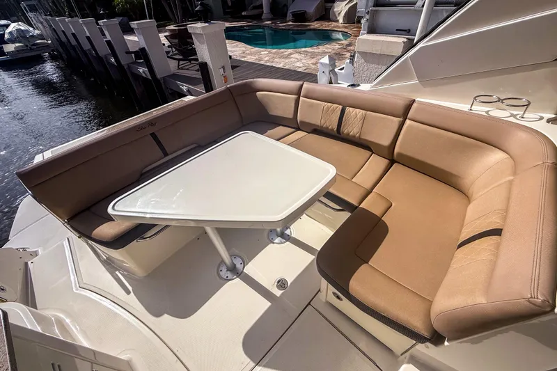 Slide: The Image of 2016 Sea Ray Sundancer 350 yacht with tan seating and white table on deck. - 12