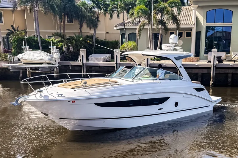 The Image of 2016 Sea Ray Sundancer 350 yacht docked near waterfront homes with palm trees. - 0